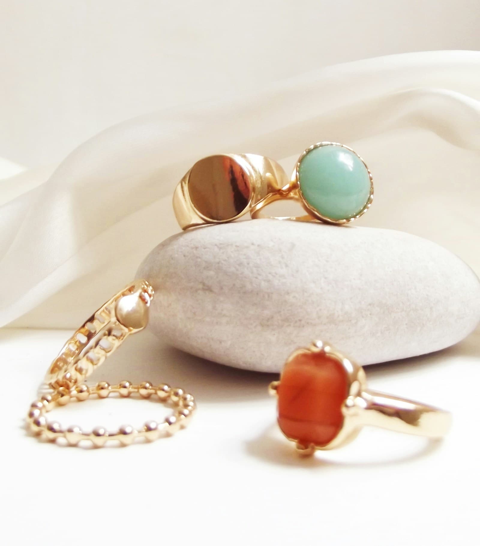 Gold rings resting against a pale stone.
